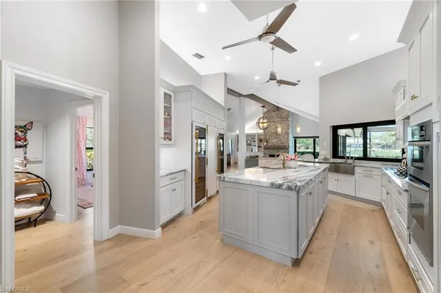 a large kitchen with stainless steel appliances kitchen island granite countertop a large counter top and a view of living room