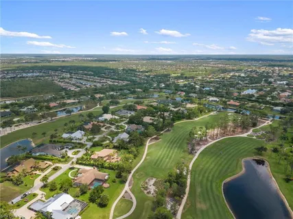 an aerial view of residential houses with outdoor space and trees