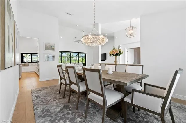 a dining room with furniture a chandelier and wooden floor