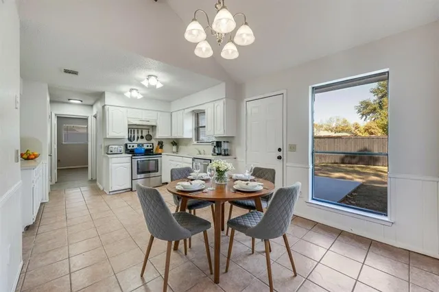a dining area with stainless steel appliances a table and chairs in it