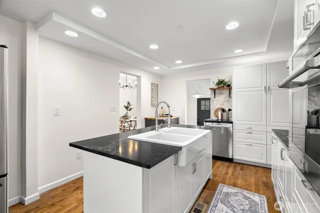 a kitchen with white cabinets and stainless steel appliances