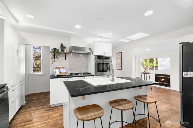 a kitchen with granite countertop a counter space a sink appliances and cabinets