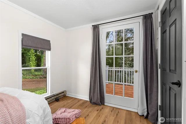 a view of a bedroom with a bed and wooden floor