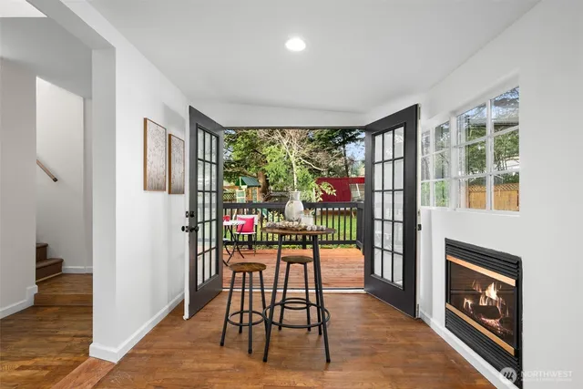 a dining room with furniture a fireplace and wooden floor