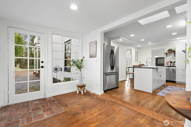 a view of a kitchen with refrigerator and white cabinets