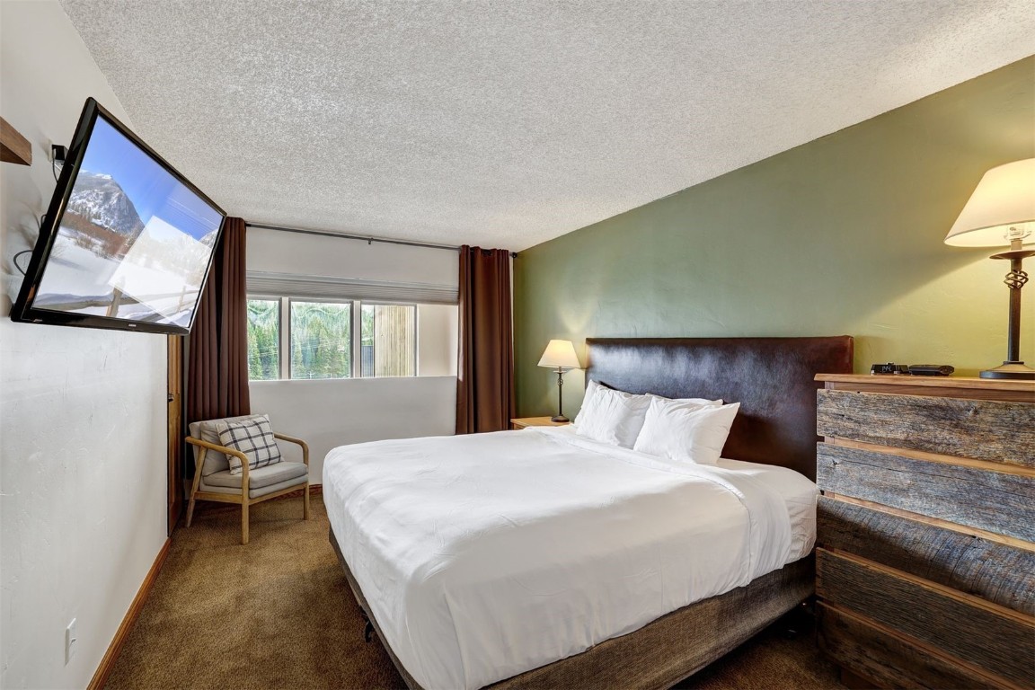 601 Village Road, Unit 503 Breckenridge, CO 80424 - Photo 13 of 48 a bedroom with a bed and wooden floor