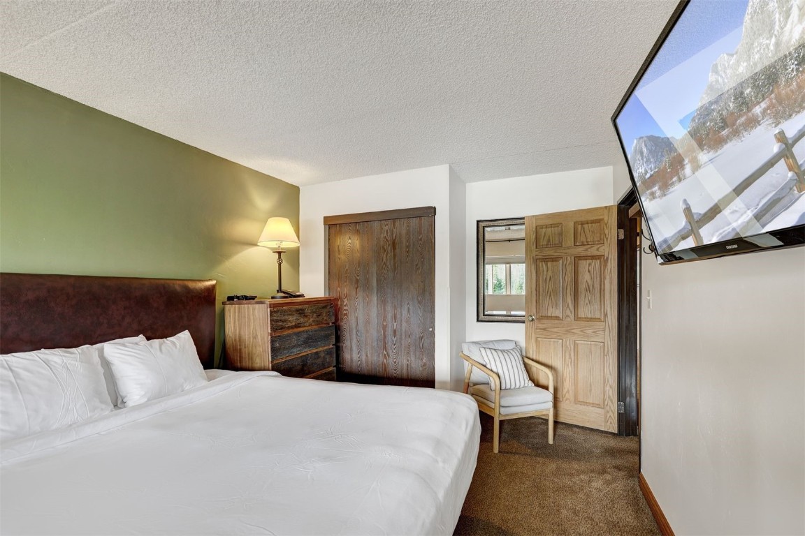 601 Village Road, Unit 503 Breckenridge, CO 80424 - Photo 15 of 48 a bedroom with a bed and a refrigerator