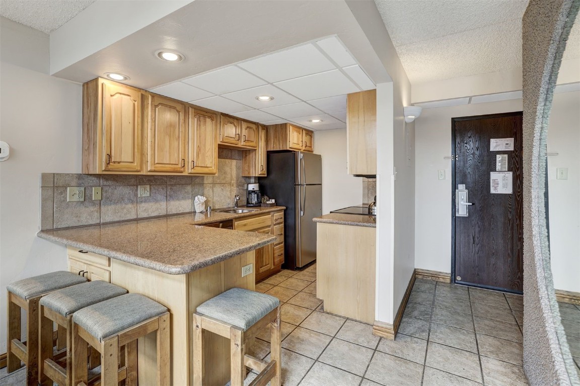 601 Village Road, Unit 503 Breckenridge, CO 80424 - Photo 9 of 48 a kitchen with a sink a refrigerator and cabinets