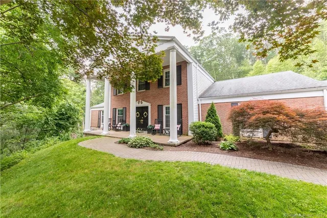a view of a house with backyard and sitting area