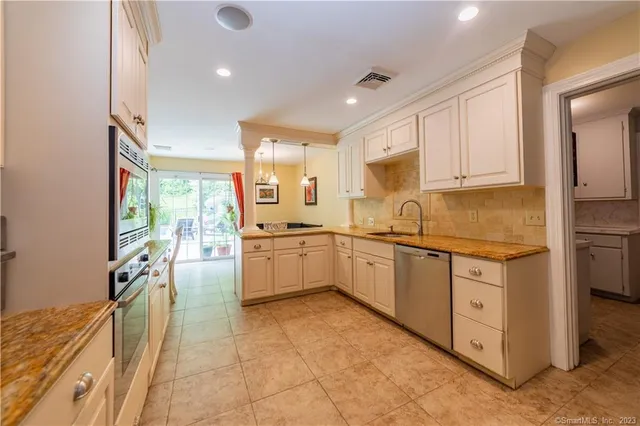 a kitchen with granite countertop a sink appliances cabinets and furniture
