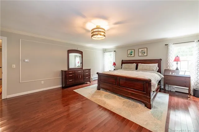 a bedroom with a bed and a night stand on dresser