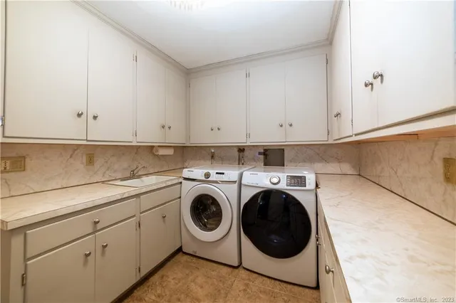 a utility room with sink dryer and washer
