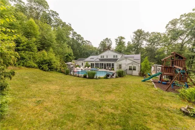 a view of a house with swimming pool and sitting area