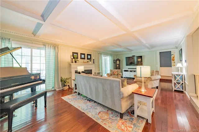 a living room with furniture a wooden floor and large windows
