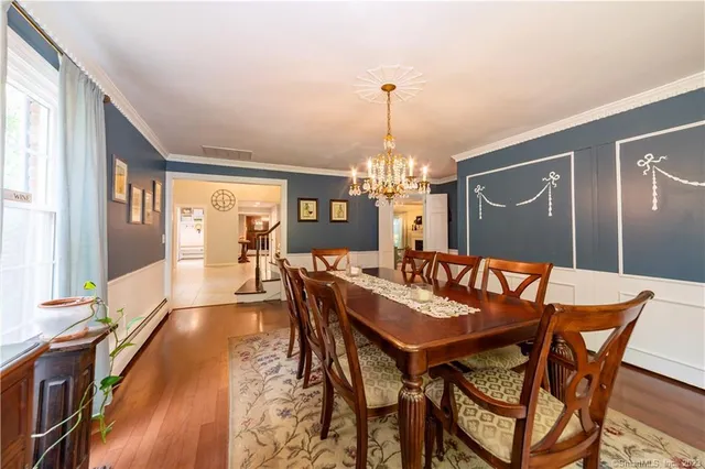 a view of a dining room with furniture a chandelier and wooden floor