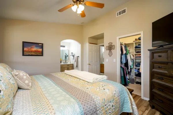 a bedroom with a large bed and a flat tv screen