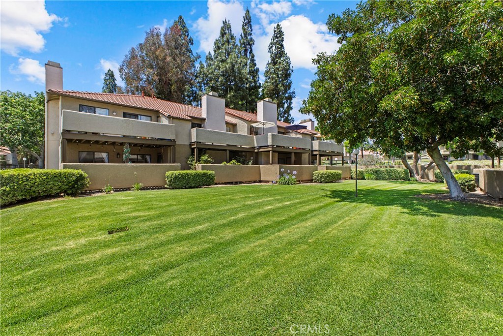 10151 Arrow Route, Unit 6 Rancho Cucamonga, CA 91730 - Photo 22 of 24 a view of a house with a big yard and large trees