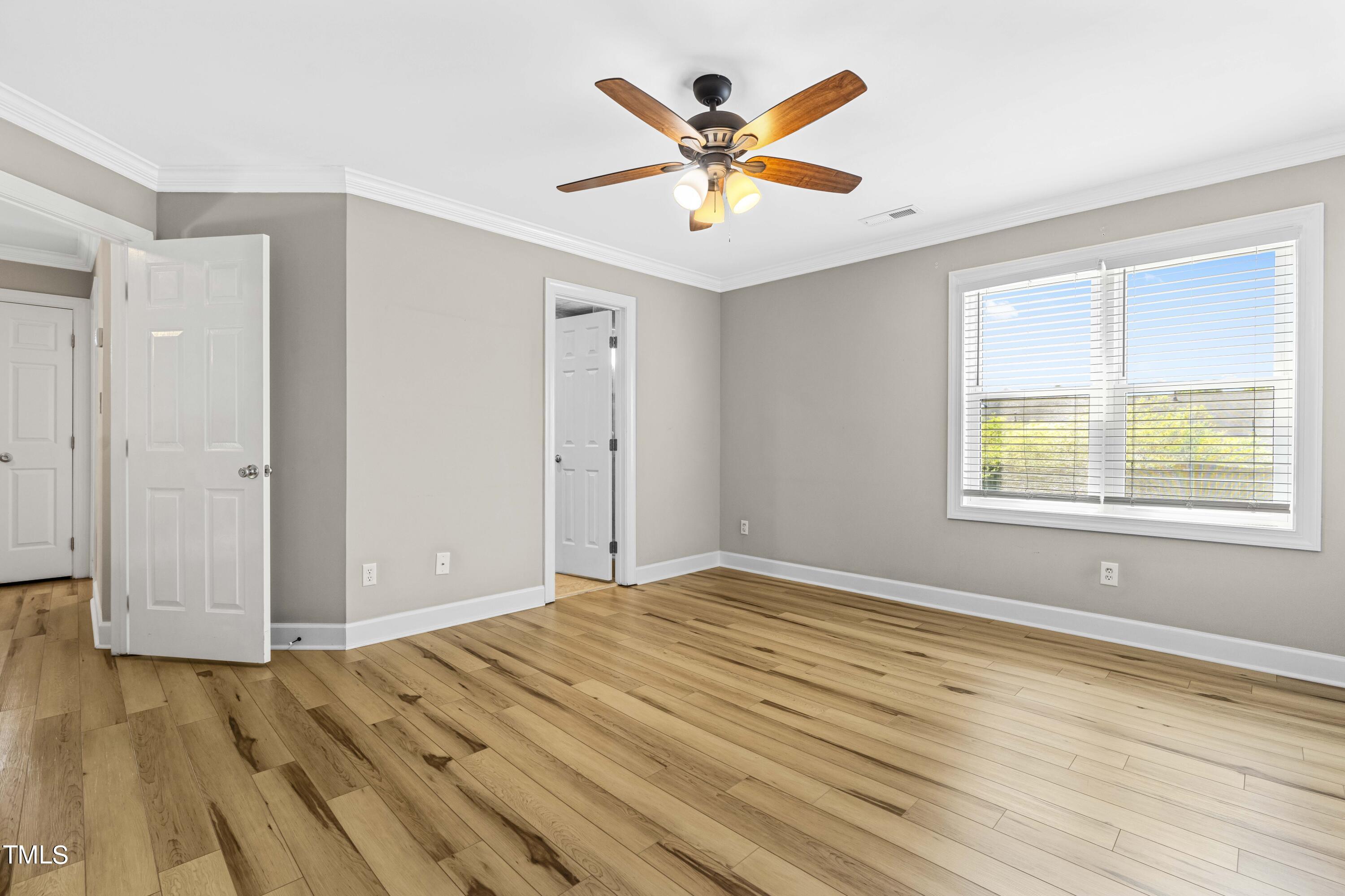 1206 Rainesview Lane Apex, NC 27502 - Photo 12 of 26 an empty room with wooden floor and windows
