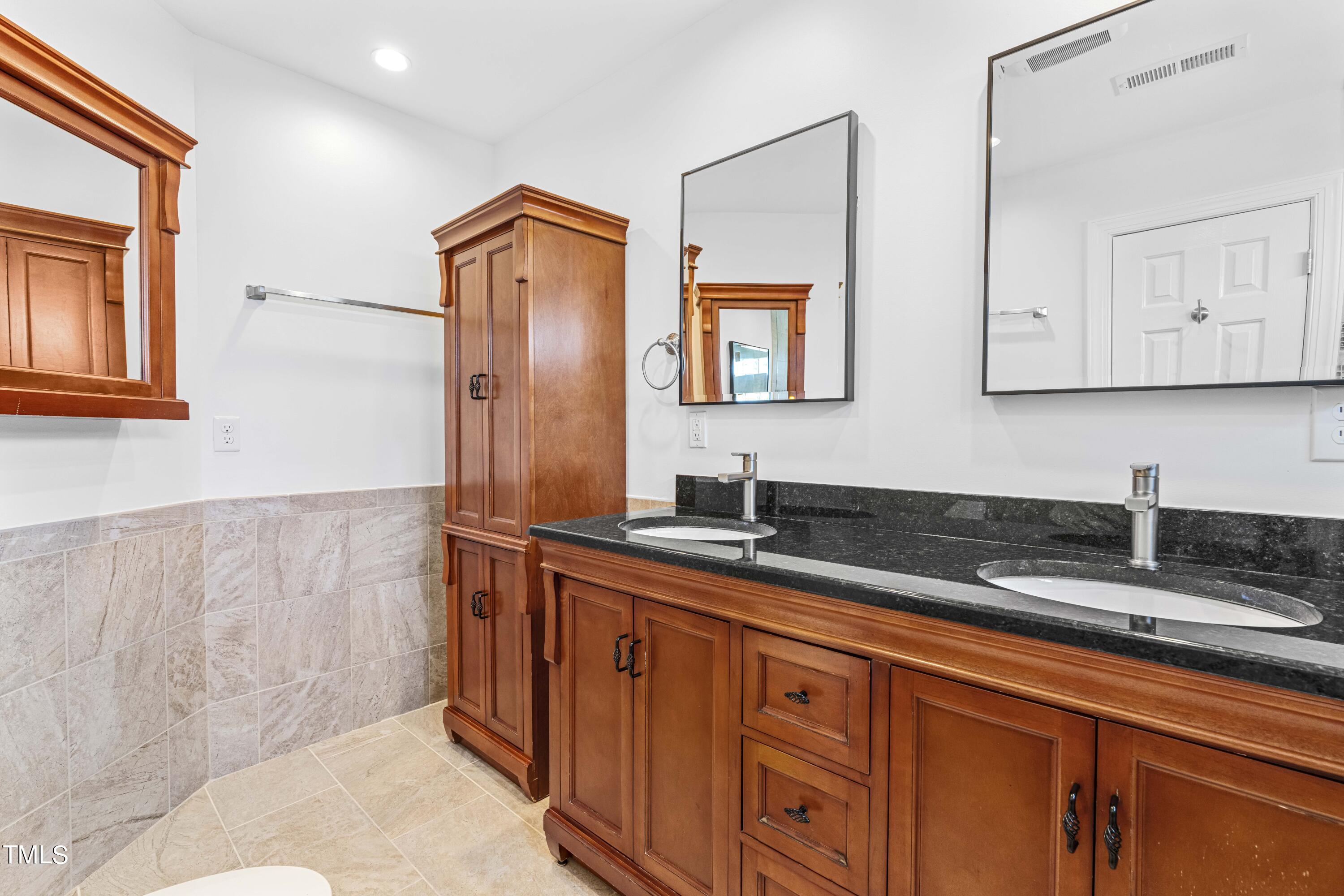 1206 Rainesview Lane Apex, NC 27502 - Photo 16 of 26 a bathroom with a granite countertop sink mirror and cabinets