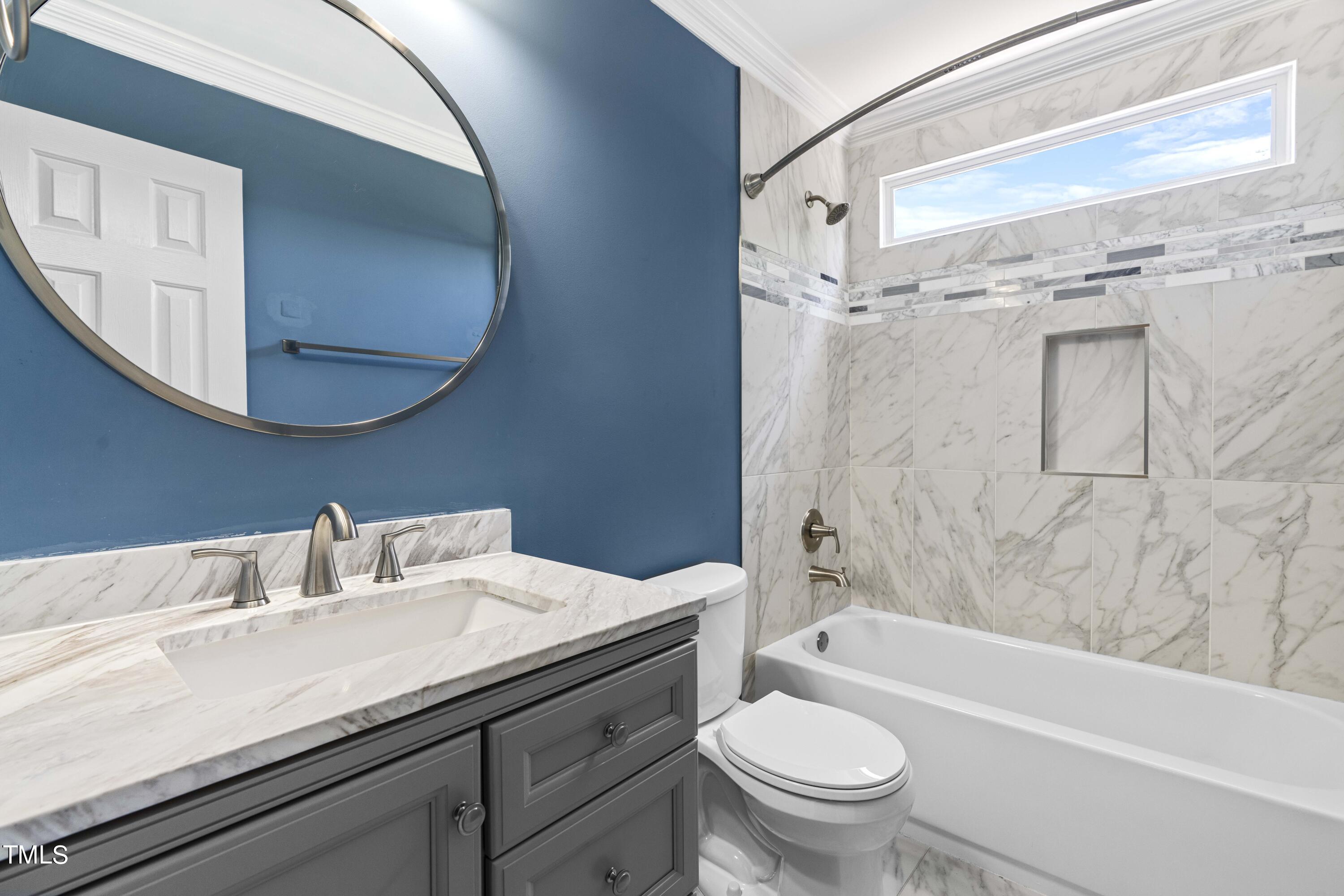 1206 Rainesview Lane Apex, NC 27502 - Photo 18 of 26 a bathroom with a sink a toilet and a mirror