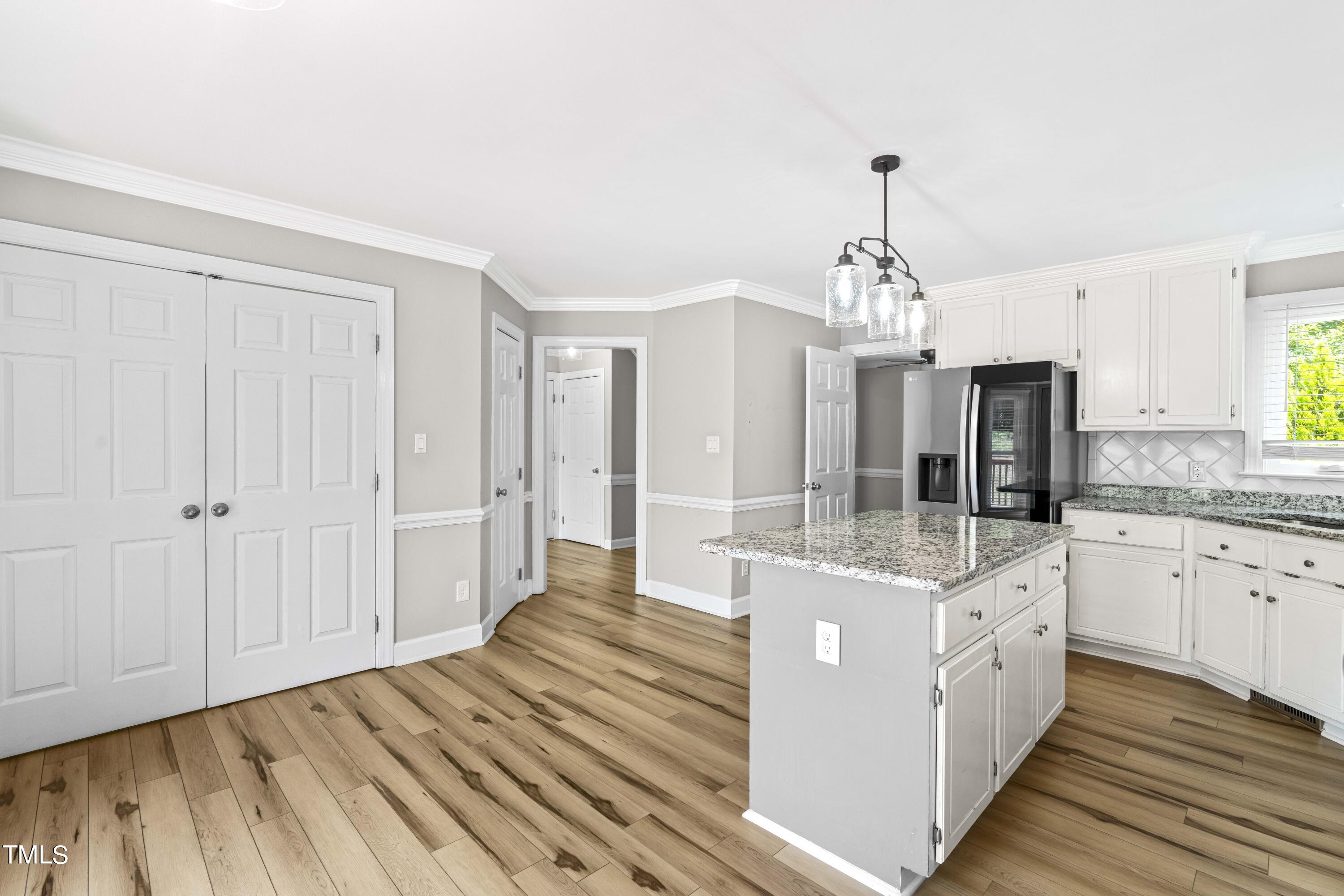 1206 Rainesview Lane Apex, NC 27502 - Photo 5 of 26 a large kitchen with kitchen island white cabinets and stainless steel appliances