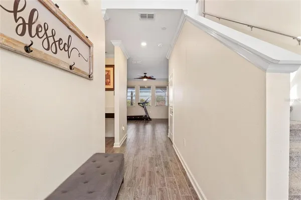 a view of a hallway with wooden floor and a bathroom