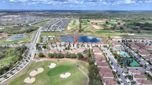 an aerial view of residential houses with outdoor space and lake view