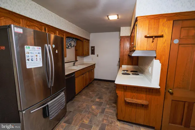 a kitchen with stainless steel appliances granite countertop a refrigerator and a stove