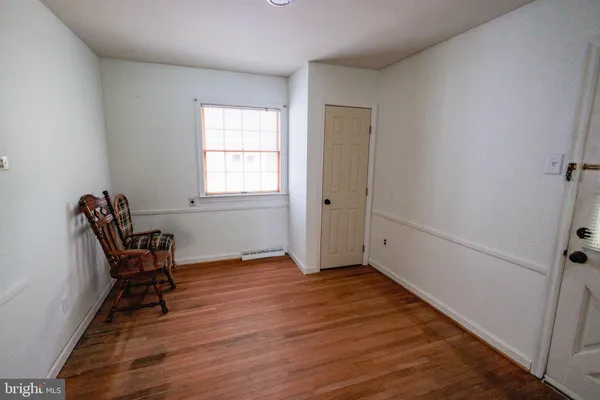 a view of a room with wooden floor lounge chair and windows