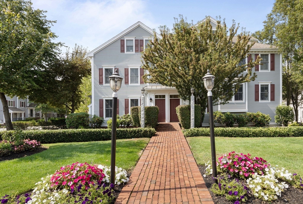 a front view of a house with a big yard and a fountain