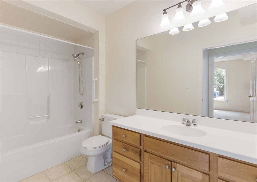 756 Washington Street, Unit A Canton, MA 02021 - Photo 11 of 20 a bathroom with a granite countertop sink a toilet and a bathtub