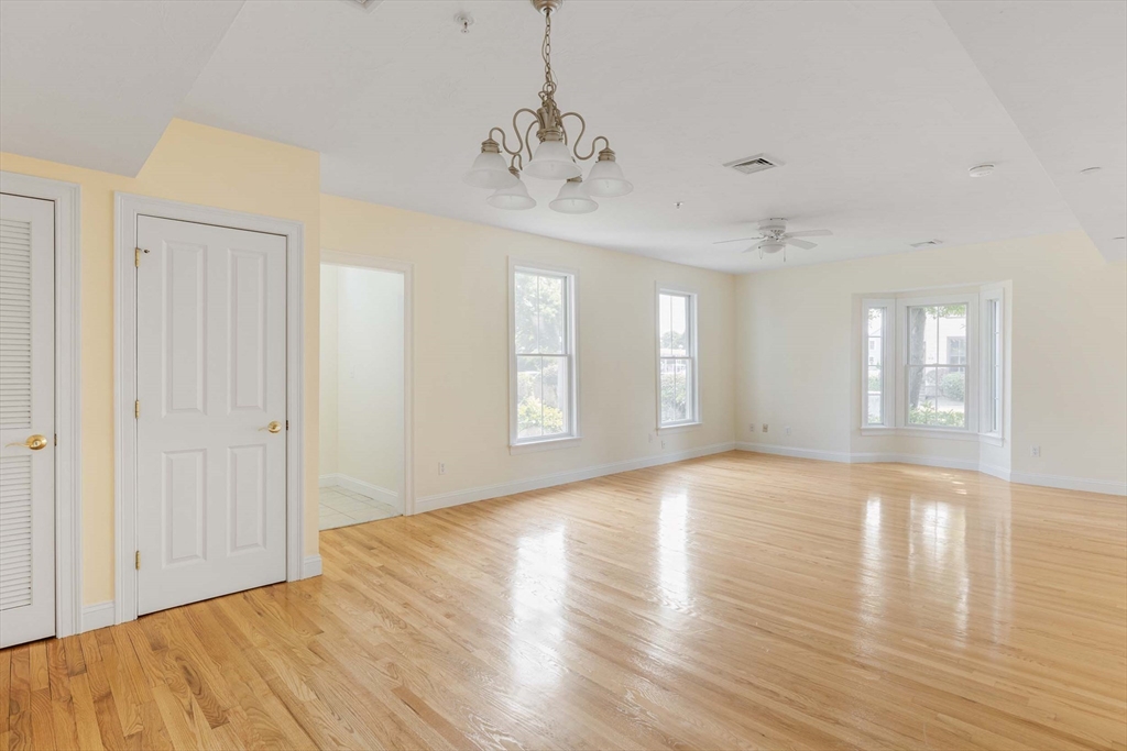 756 Washington Street, Unit A Canton, MA 02021 - Photo 3 of 20 a view of an empty room with wooden floor and a window