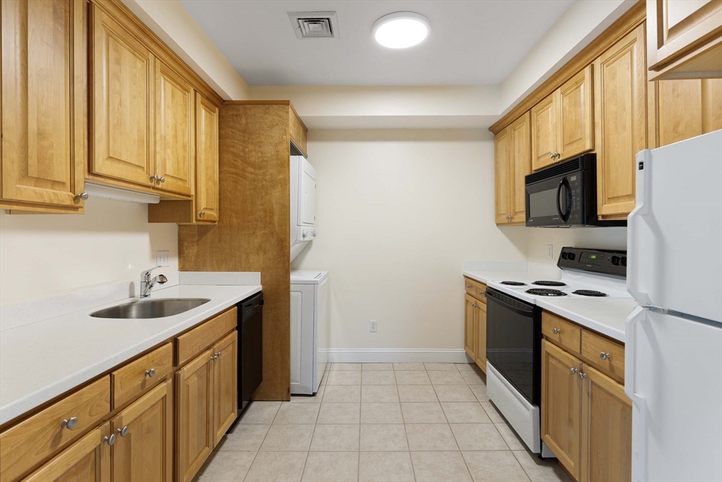756 Washington Street, Unit A Canton, MA 02021 - Photo 6 of 20 a kitchen with a sink a stove top oven and cabinets