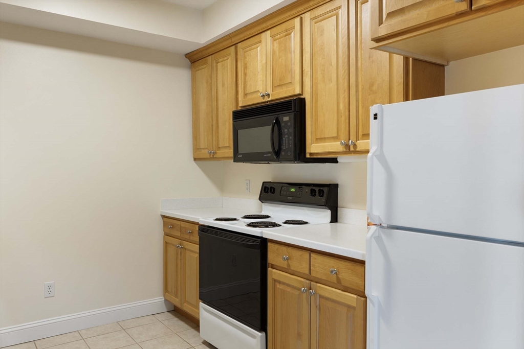 756 Washington Street, Unit A Canton, MA 02021 - Photo 8 of 20 a kitchen with a refrigerator a stove top oven