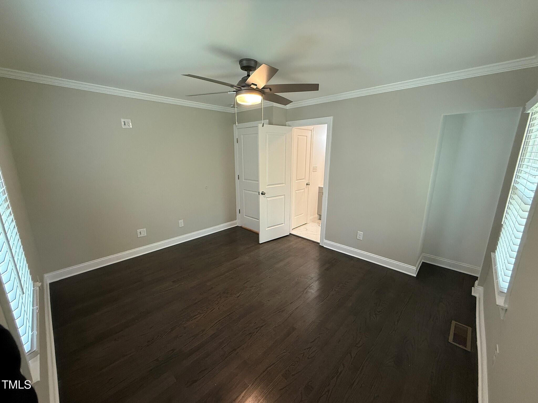 215 Walnut Street Cary, NC 27511 - Photo 20 of 33 an empty room with wooden floor fan and windows