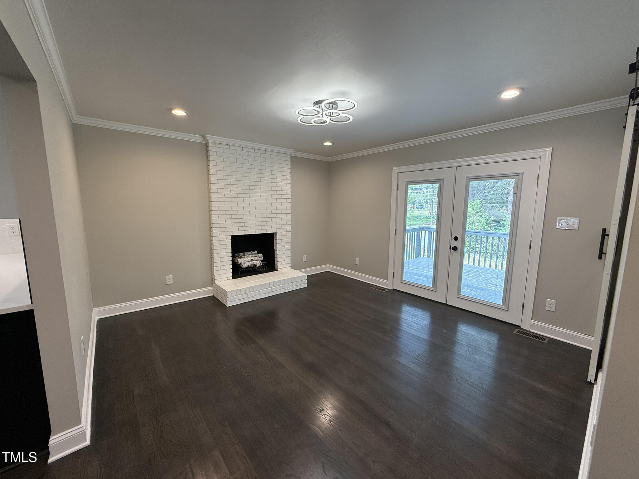 215 Walnut Street Cary, NC 27511 - Photo 9 of 33 an empty room with wooden floor and fireplace