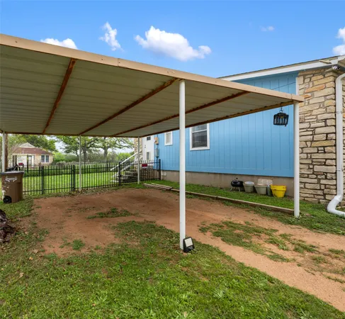 a view of a backyard with table and chairs under an umbrella
