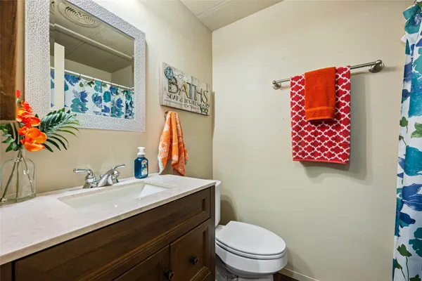 a bathroom with a sink mirror vanity and toilet