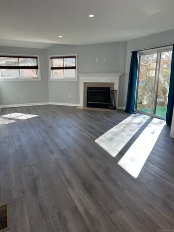 an empty room with wooden floor and fireplace