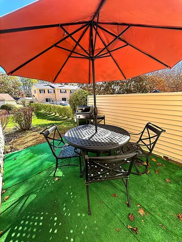 a view of a patio with table and chairs under an umbrella