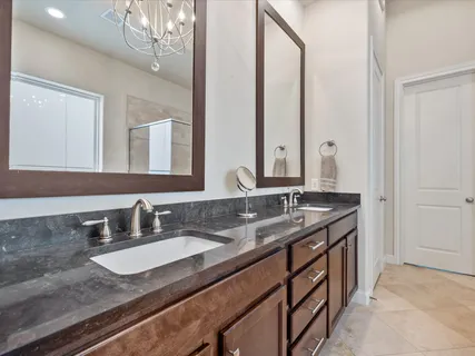 a spacious bathroom with a granite countertop tub sink shower and mirror