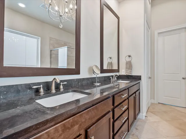 a spacious bathroom with a granite countertop tub sink shower and mirror