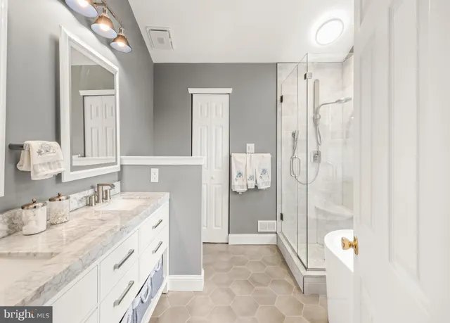 a bathroom with a sink vanity granite tub shower and mirror