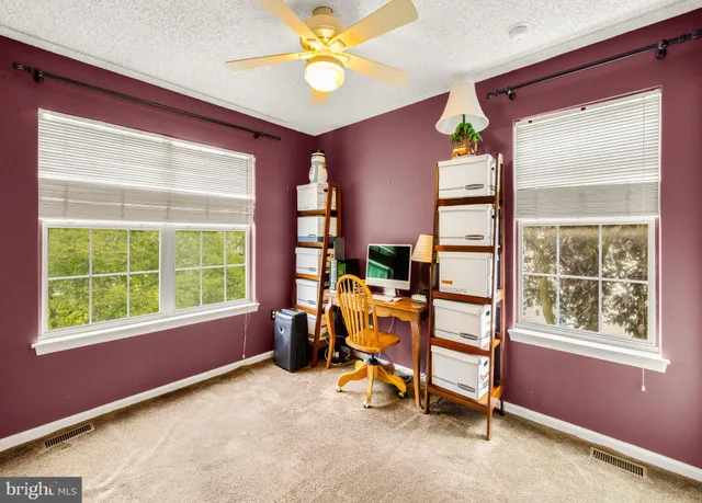 a view of a workspace with furniture and a window