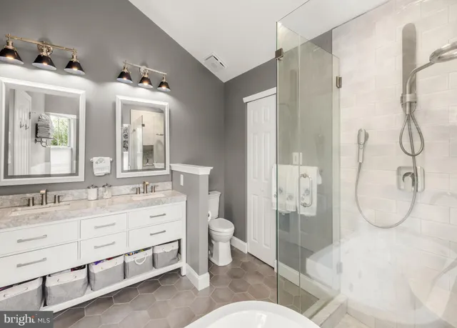 a bathroom with a double vanity sink mirror and toilet