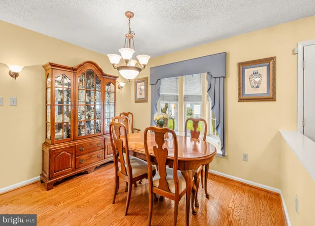 a dining room with furniture a chandelier and wooden floor