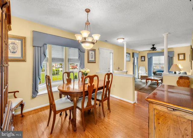 a view of a dining room with furniture wooden floor and chandelier