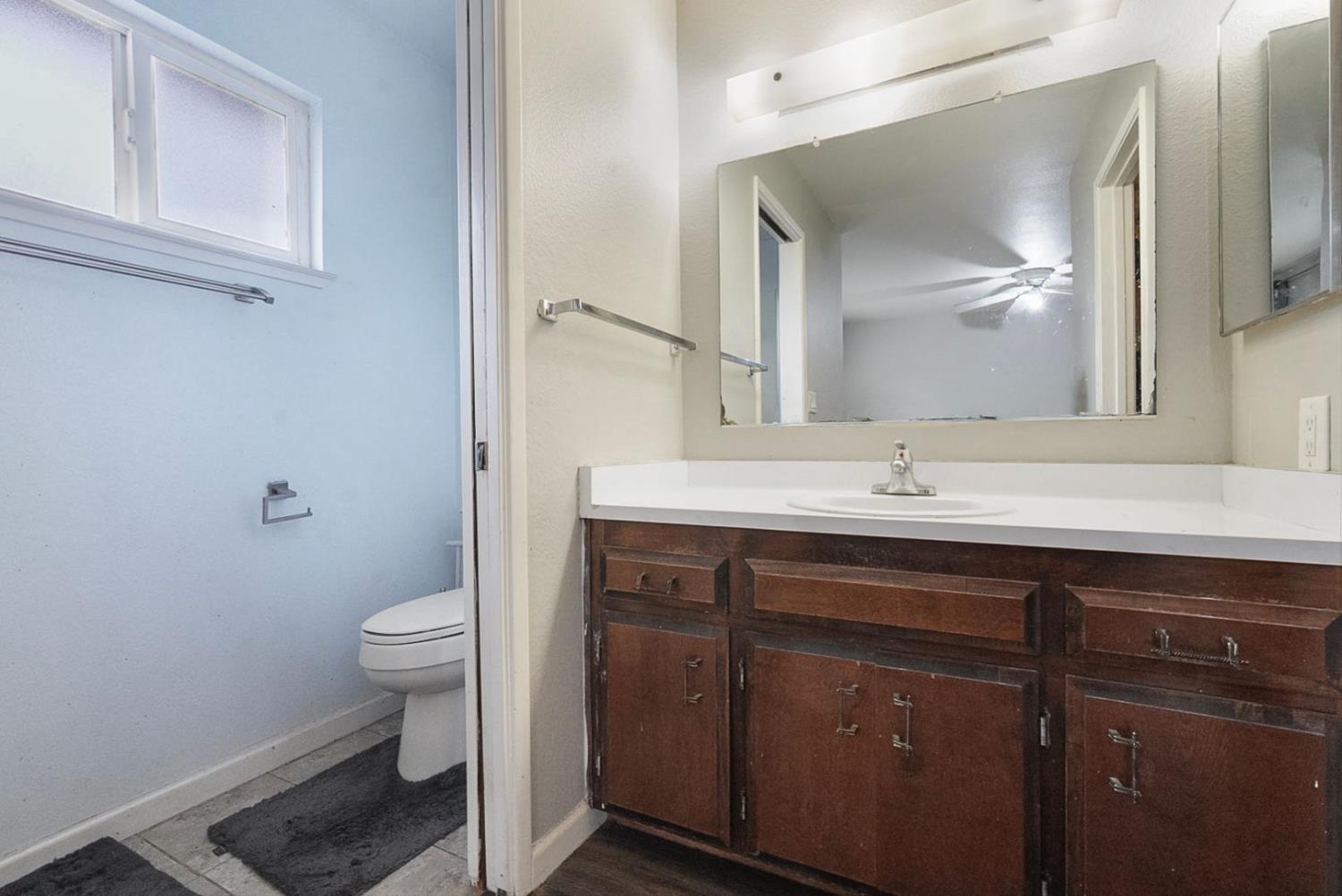 3360 Stanley Avenue Turlock, CA 95382 - Photo 15 of 17 a bathroom with a sink a toilet and a mirror