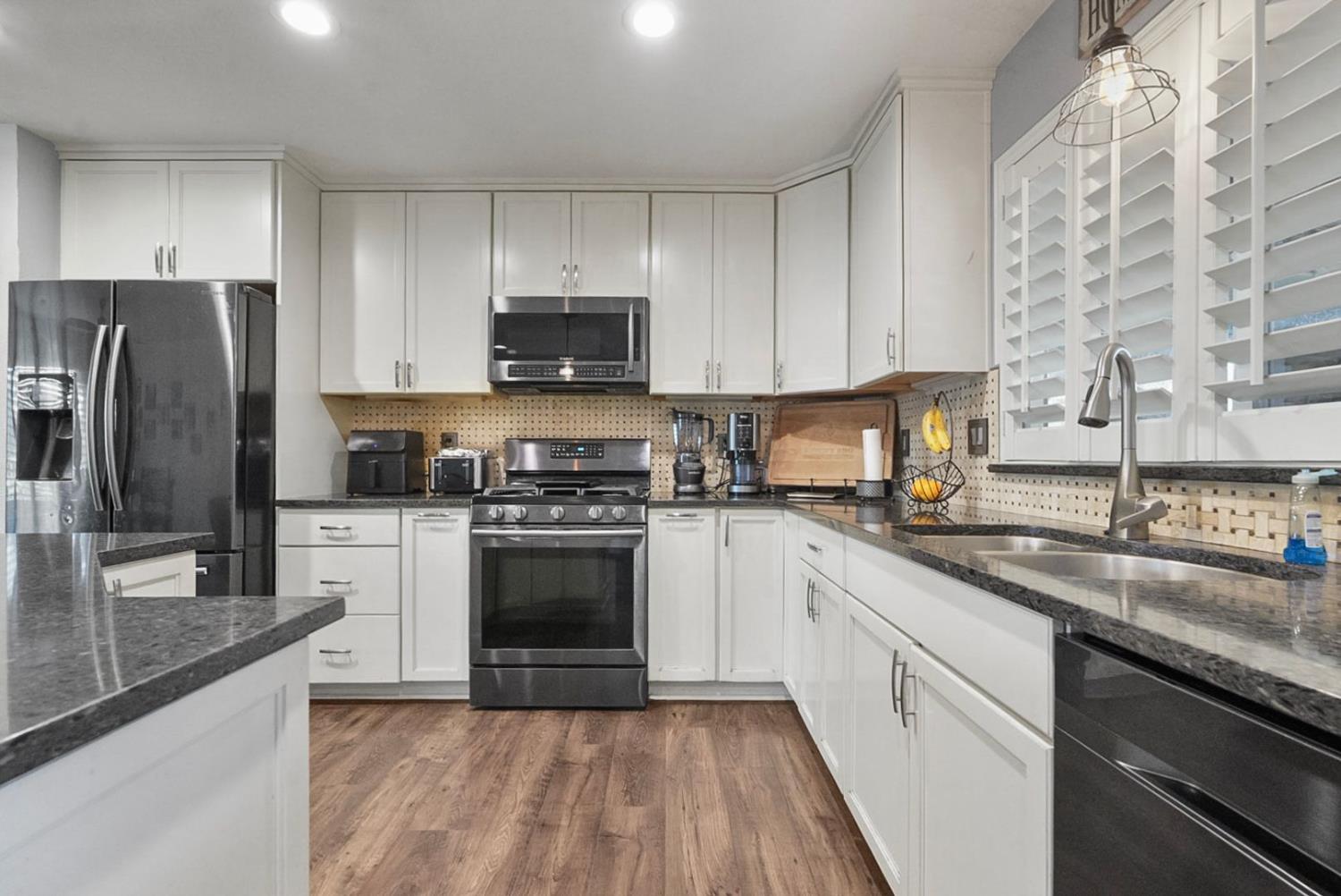 3360 Stanley Avenue Turlock, CA 95382 - Photo 7 of 17 a kitchen with stainless steel appliances granite countertop a sink stove microwave and refrigerator