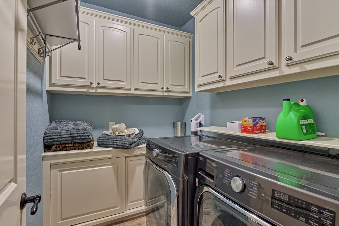 19089 Grandview Point Montgomery, TX 77356 - Photo 33 of 48 This is a well-organized laundry room featuring ample overhead cabinetry for storage and a convenient countertop space for sorting and folding.